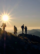 Bei uns liegen die schönsten Wege direkt vor der Tür Gruppe von Wanderern auf einem Berggipfel