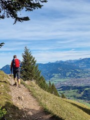 Unsere Gäste fahren gratis mit der Bergbahn Wanderer auf einem Pfad, umgeben von Bergen