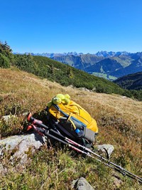 Mit unserer Wander-Packliste vergessen Sie garantiert nichts Wanderrucksack & Wanderstöcke auf einem Stein