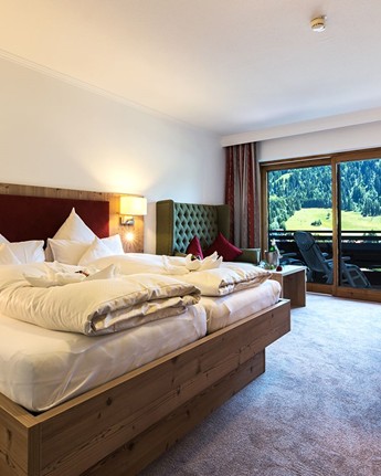 Doppelzimmer mit Holzelementen und freiem Blick auf die Natur Hotelzimmer mit Doppelbett, Sitzecke & Balkon