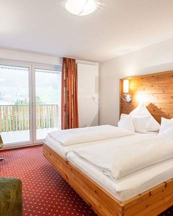 Hotelzimmer mit Doppelbett, Schreibtisch, Sessel & Balkon