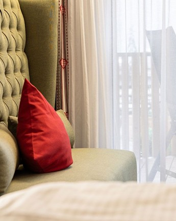 Gemütliche Auszeit im Doppelzimmer mit beruhigendem Naturblick Couch vor einem großen Fenster