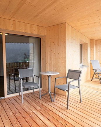 Großer Balkon mit Tisch und Stühlen