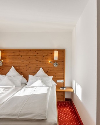 Ihr Zimmer mit traumhaftem Blick auf die Berge und Natur Doppelbett im Hotelzimmer