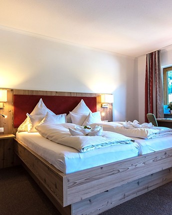 Modernes Doppelzimmer mit natürlichem Design und Waldblick Doppelbett & Kleiderschrank im Hotelzimmer