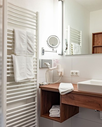 Naturinspiriertes Badezimmer mit eleganten Holzelementen Waschbecken & Spiegel im Hotelbadezimmer