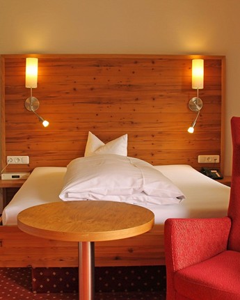 Hotelzimmer mit Einzelbett, Sessel & Fernseher