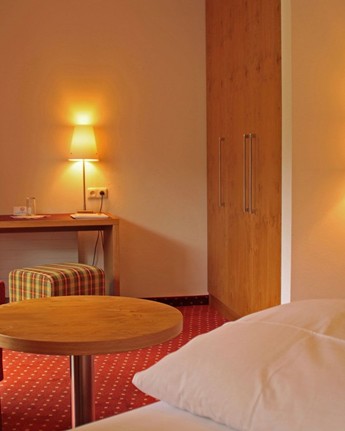 Hotelzimmer mit Sessel, Schreibtisch & Fernseher