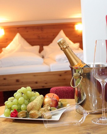 Obstteller & Sekt auf einem Tisch im Hotelzimmer