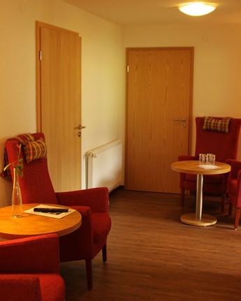 Tische, Sessel & ein Fernseher im Hotezimmer