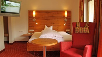 Hotelzimmer mit Einzelbett, Sessel & Fernseher