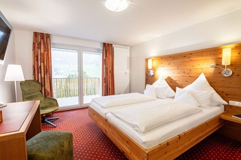 Hotelzimmer mit Doppelbett, Schreibtisch, Sessel & Balkon