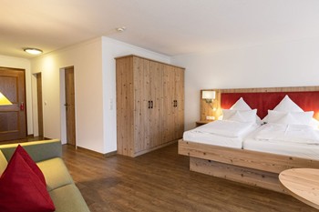 Hotelzimmer mit Doppelbett, Couch & Kleiderschrank