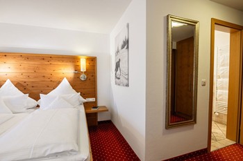 Doppelbett im Hotelzimmer, Blick ins Badezimmer