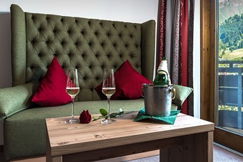 Couch & Couchtisch mit Sektflasche, Gläsern und einer Rose darauf