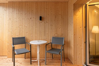 Tisch und Stühle auf einem Holzbalkon