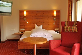 Hotelzimmer mit Einzelbett, Sessel & Fernseher