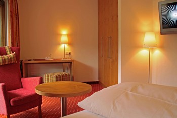 Hotelzimmer mit Sessel, Schreibtisch & Fernseher