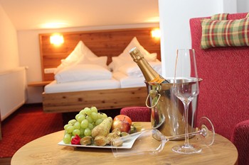 Obstteller & Sekt auf einem Tisch im Hotelzimmer