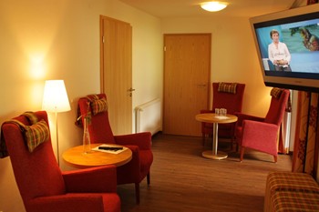 Tische, Sessel & ein Fernseher im Hotezimmer