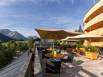 Tische & Stühle auf der Terrasse mit Blick auf die Berge