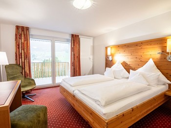 Alpiner Charme: Entspannen Sie im komfortablen Doppelzimmer Hotelzimmer mit Doppelbett, Schreibtisch, Sessel & Balkon