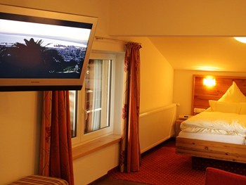 Suite zum Wohlfühlen: Der perfekte Ort zum Entspannen nach einem Abenteuer Hotelzimmer mit Doppelbett & Fernseher