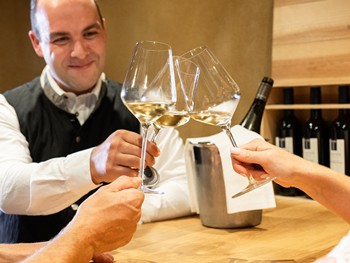 Lassen Sie sich von unseren Sommeliers beraten Drei Sommeliers stoßen mit Wein an