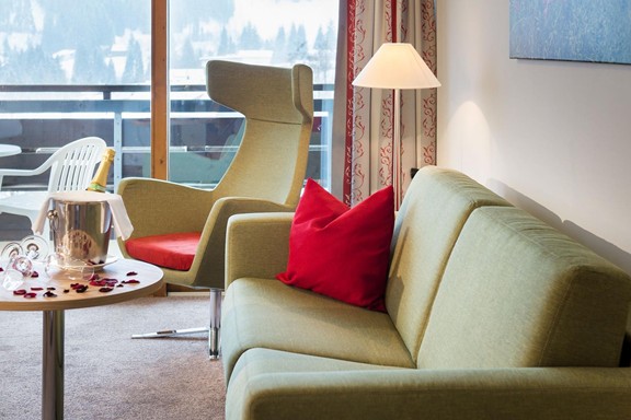 Sitzecke im Hotelzimmer mit Sekt und Rosenblättern dekoriert