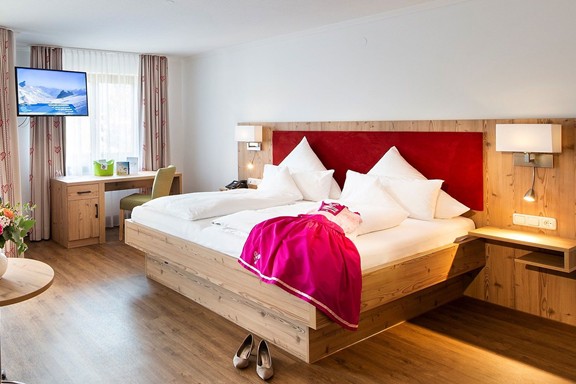 Sich schon mal die Entspannung für morgen sichern Hotelzimmer mit Doppelbett mit Dirndl darauf